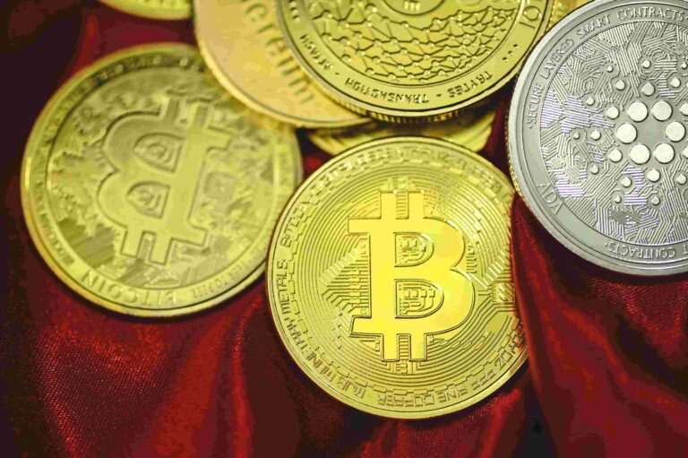 Gold Bitcoin coin on a red velvet background symbolising cryptocurrency investment.